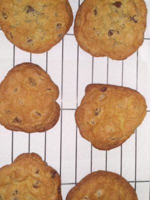 Fresh baked chocolate chip cookies cooling on a baking rack